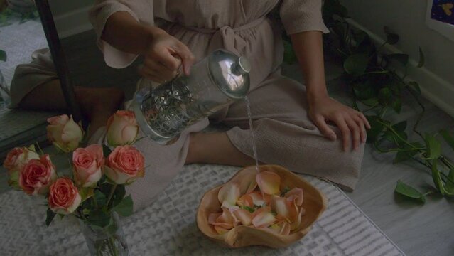 Young woman pouring water into flowers