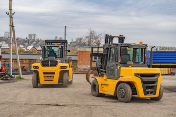 two yellow forklifts while working on cargo transportation.
