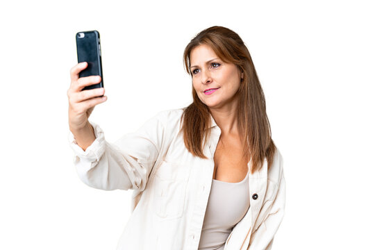 Middle age woman over isolated background making a selfie