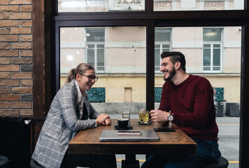Two business people from different companies dating and hiding in cafeteria so colleagues cant see them together. Businesspeople date night drinking coffee and tea sitting in the bar.