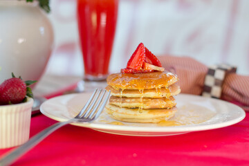 Pancakes with strawberries and syrup