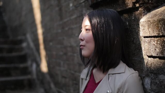 Asian young model stand against the brick wall.