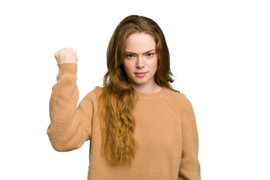 Young caucasian redhead woman isolated showing fist to camera, aggressive facial expression.