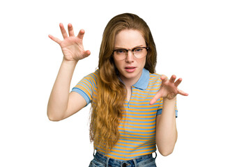 Young caucasian redhead woman isolated upset screaming with tense hands.