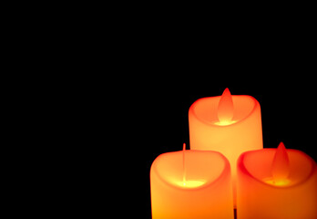 Orange candle with light shines in the shadows. Advent concept.
