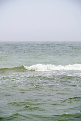 Undulating Baltic Sea in autumn foggy weather.