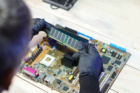 inserting ram into motherboard from computer on table