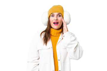 Middle age woman wearing winter muffs over isolated chroma key background with surprise and shocked facial expression