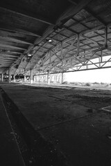 Metal structures old, abandoned aircraft hangar in black and white photo.
