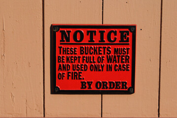 Close Up of Red Painted Cast Iron Sign at Old Railway Station 