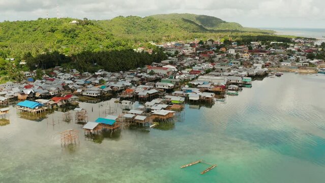 Village of stilt houses built over the sea, top view. Dapa, Siargao, Philippines.