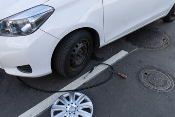  Inflating a tire with air and checking air pressure with gauge pressure in service station. Flat tire concept. Punctured car tire.