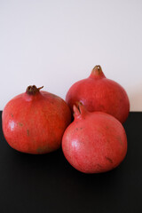 ripe pomegranates on black background, antioxidant and health care concept