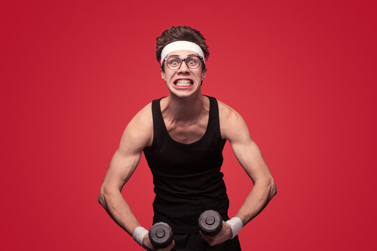 Weak nerd exercising with dumbbells