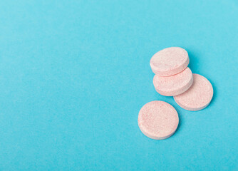 Colored medical pills on a blue background. Vitamins. Health concept. Immunity drug. Space for copy. Space for text.