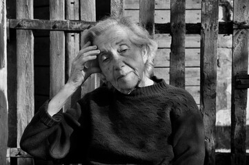 portret of an unpappy sitting elderly woman - obrazy, fototapety, plakaty