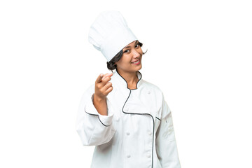 Young chef Argentinian woman over isolated background points finger at you with a confident...