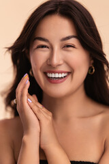 Asian woman clasping hands and laughing