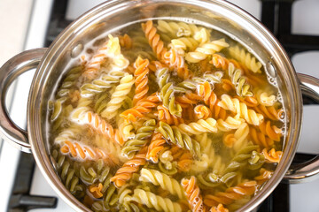 Italian fusilli paste is cooked in a pot on the stove. Top view. Selective focus.