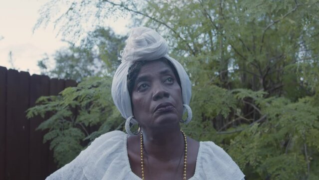 Woman in all white with headwrap in nature 