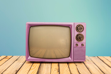 Vintage pink television on office table with blue banner background