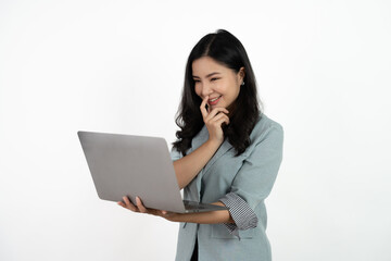 Happy asian business woman holding laptop computer and looking at the camera over white background.