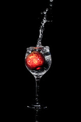 Splash photography capturing an apple inside a glass cup