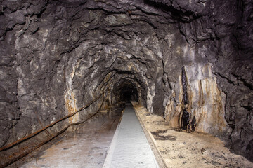 Obraz premium Underground abandoned white calcite marble ore mine shaft tunnel gallery passage with rails