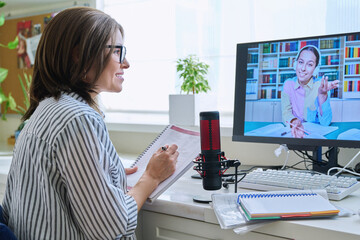 Obraz na płótnie Canvas Mature woman talking online with teenage girl using video call