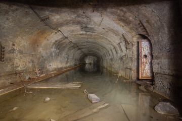 Old iron ore mine underground tunnel flooded with water and timbering