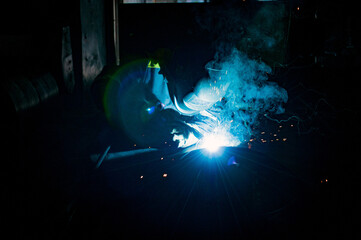 welder making weld joint with electric arc welding device