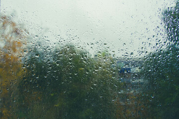 Drops on glass after rain. Autumn weather outside window. Rain outside window.
