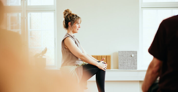 Yoga teacher leading a class in her studio