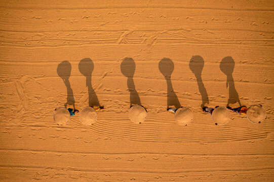 Aerial view of farmers working in a field drying rice on a rice field in Dhamrai, Dhaka, Bangladesh.
