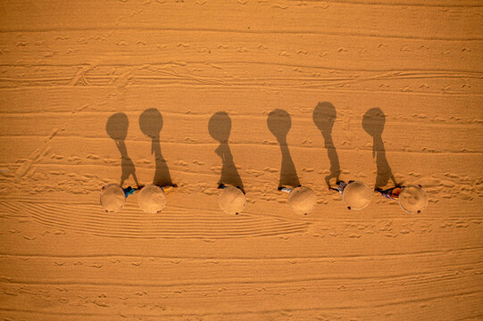 Aerial view of farmers working in a field drying rice on a rice field in Dhamrai, Dhaka, Bangladesh.
