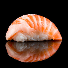 Nigiri sushi with rice and smoked salmon on black.