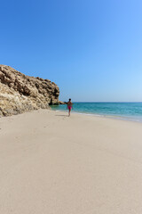 Woman alone at a wild and idyllic Beach of Ras Al Jinz, Oman