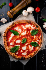 Red Neapolitan pizza with mozzarella, tomato sauce, spinach on a thick dough with spices.