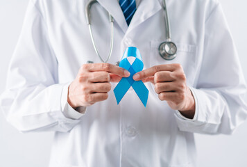 doctor in a white coat hands holding Blue ribbon for supporting people living and illness, Colon cancer, Colorectal cancer, Child Abuse awareness, world diabetes day, International Men's Day