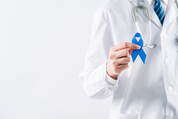 doctor in a white coat hands holding Blue ribbon for supporting people living and illness, Colon cancer, Colorectal cancer, Child Abuse awareness, world diabetes day, International Men's Day