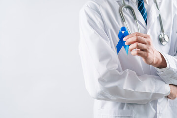 doctor in a white coat hands holding Blue ribbon for supporting people living and illness, Colon cancer, Colorectal cancer, Child Abuse awareness, world diabetes day, International Men's Day