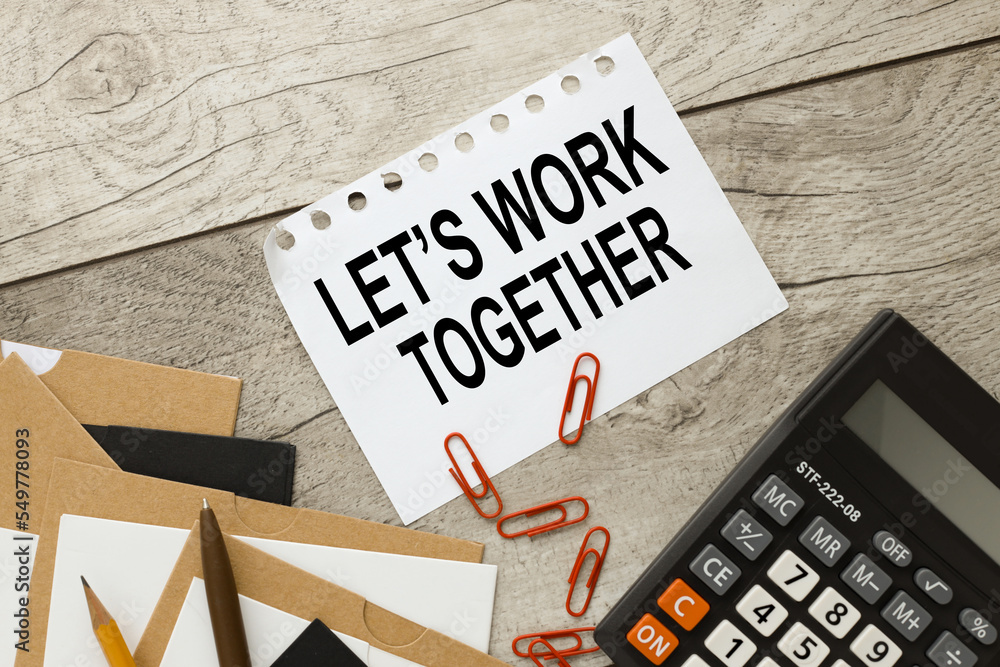 Poster let's work together. text on a notebook close-up. desktop calculator
