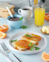 Sandwiches with marmalade, orange juice and coffee ready for breakfast