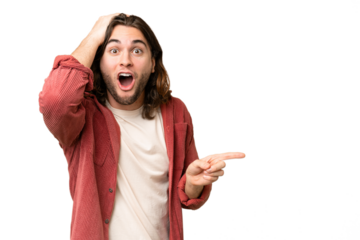 Young handsome man over isolated background surprised and pointing finger to the side