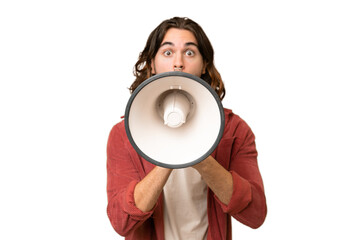 Young handsome man over isolated background shouting through a megaphone