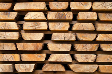 Stack of lumber of a wooden board from a tree, close-up, background. Wooden boards at the sawmill, carpentry workshop. Sawing and air drying of wood. Woodworking industry. Wooden boards.