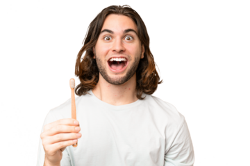 Young handsome man brushing teeth over isolated background with surprise and shocked facial expression