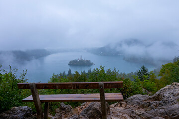 Aerial view of Island in Bled Lake, with Bled city in background. Church and other buildings in the...