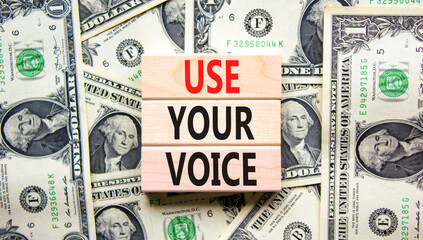 Use your voice symbol. Concept words Use your voice on wooden blocks on a beautiful background from dollar bills. Business and use your voice concept. Copy space.