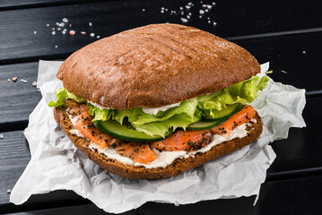 Sandwich with fish salmon, lettuce, cucumber and mayonnaise.